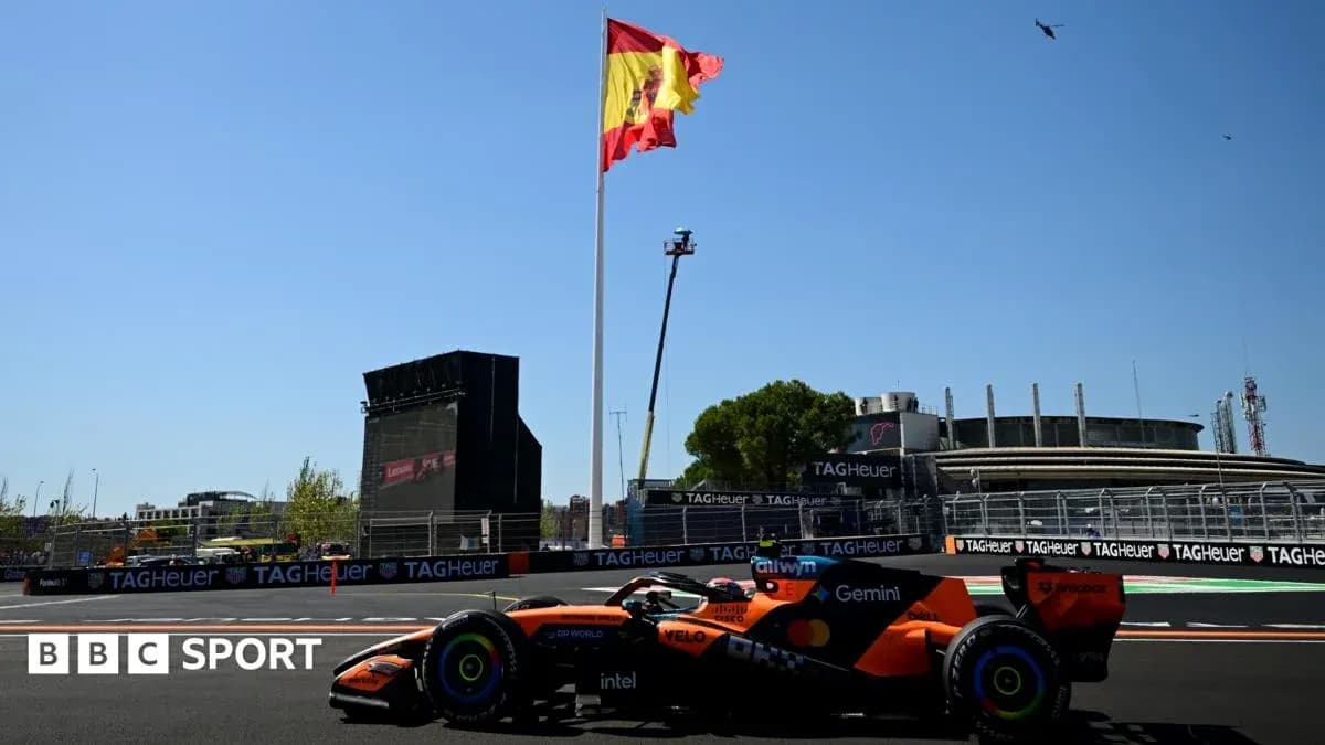 Formula 1 car driving past Spanish flag at circuit