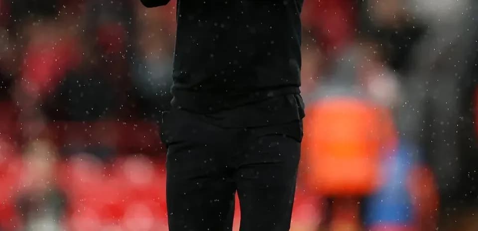 Coach applauding during a rainy match