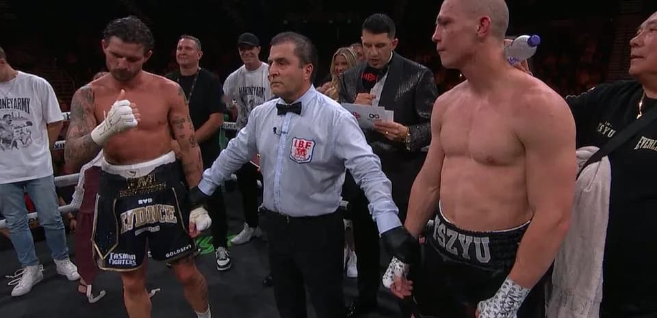 Boxers waiting for decision with referee in ring