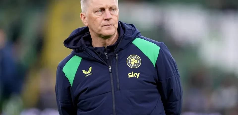 Coach in team jacket observing the field