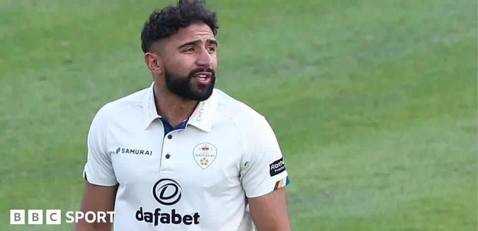 Cricketer in white uniform on the field
