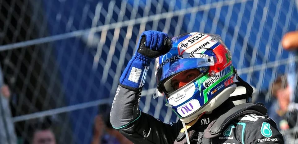 Racing driver celebrating with raised fist in helmet