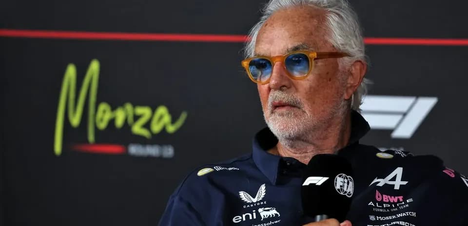 Man speaking at press conference with Monza backdrop