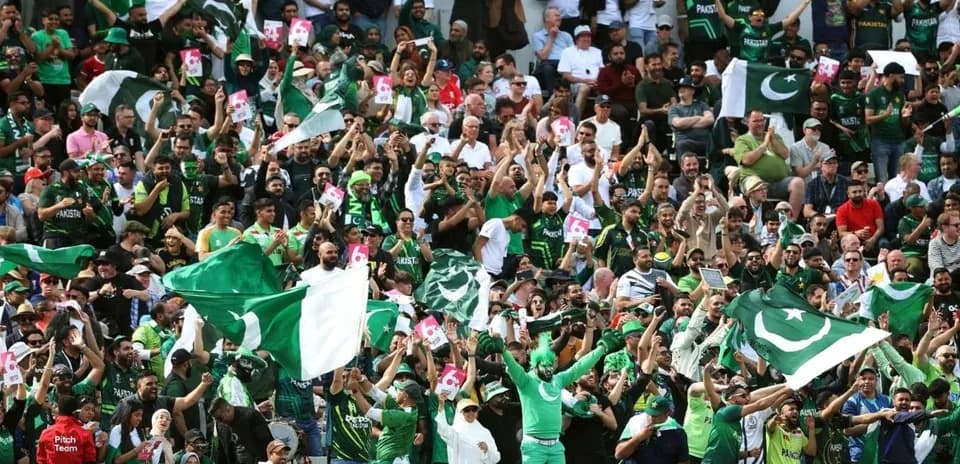 Crowd of fans cheering with flags at stadium
