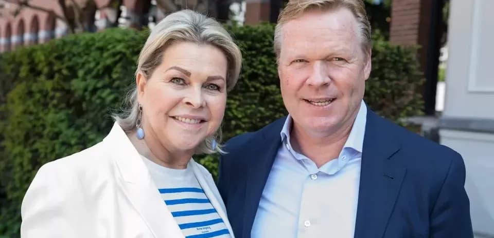 Two people posing together outdoors with greenery