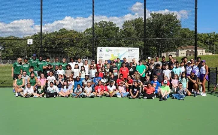 Group photo of participants on tennis court