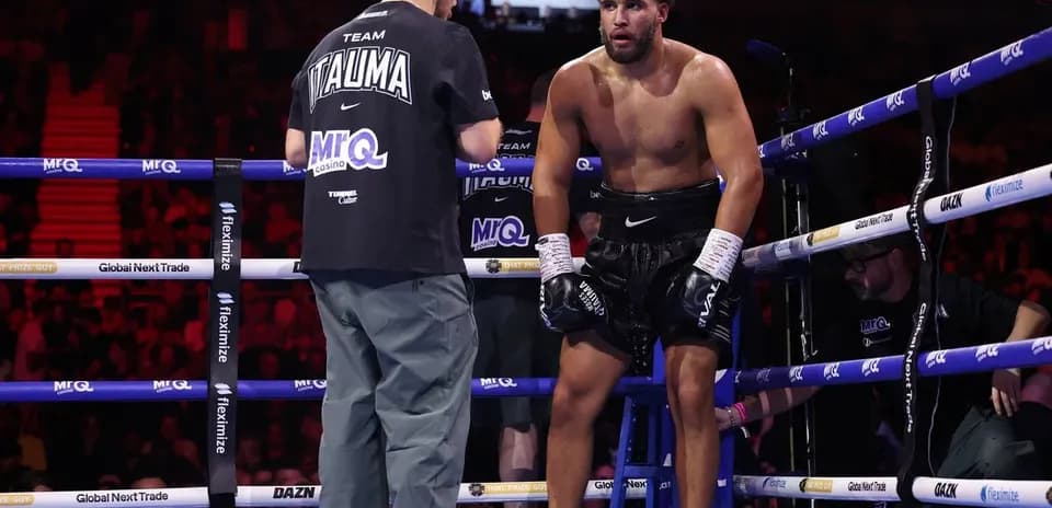 Boxer sitting on stool receiving advice from coach