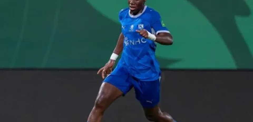 Player in blue kit dribbling ball on field