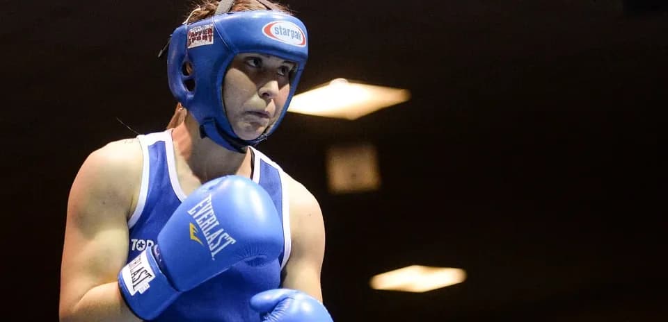 Female boxer preparing for a match in blue gear