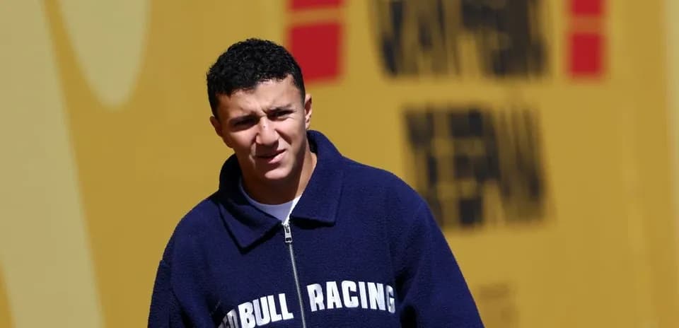Driver in Red Bull Racing jacket walking outdoors
