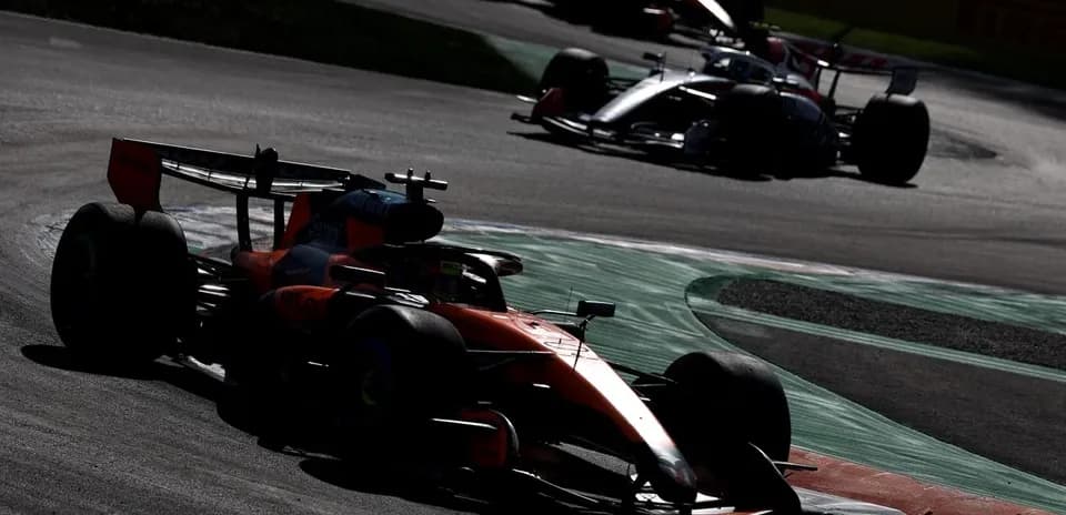 Formula 1 cars racing on a curved track