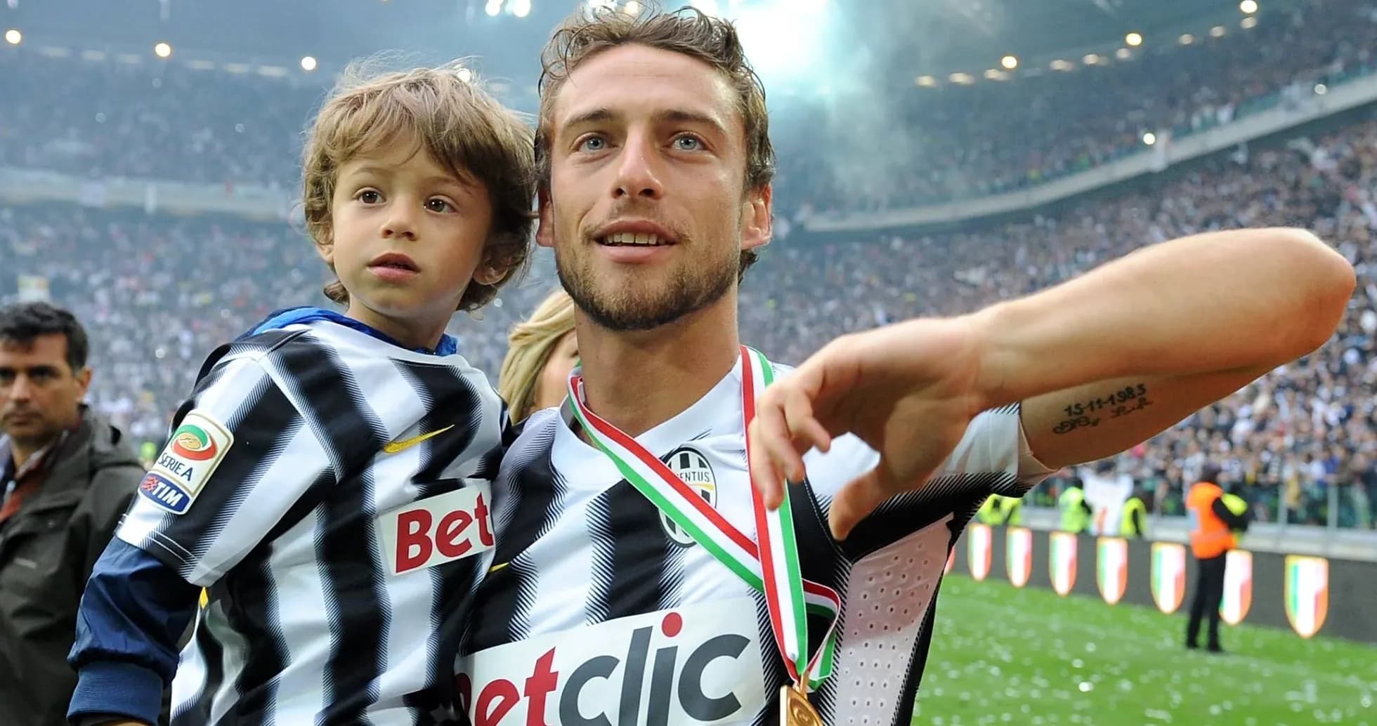 Player holding child, celebrating victory in stadium