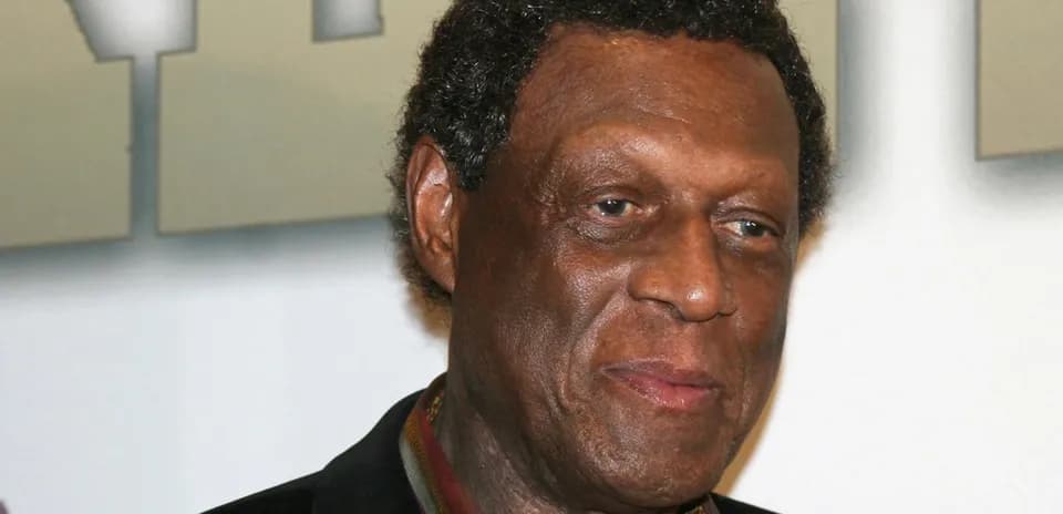 Close-up of a man with curly hair smiling