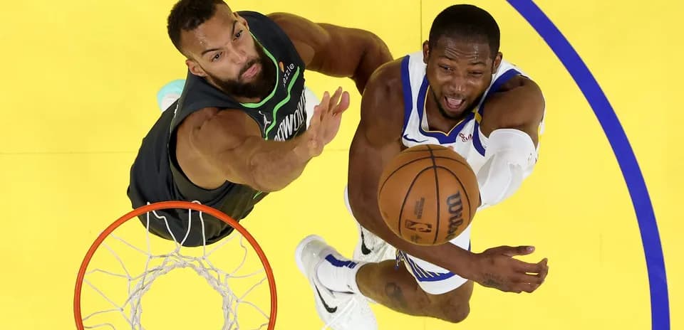 Player attempting a shot while defended under the basket
