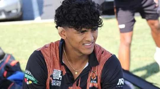 Player sitting on the grass, wearing team shirt