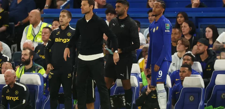 Coaching staff and player on the bench during match