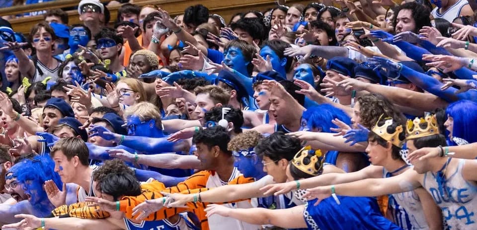 Duke fans in blue paint cheering at game