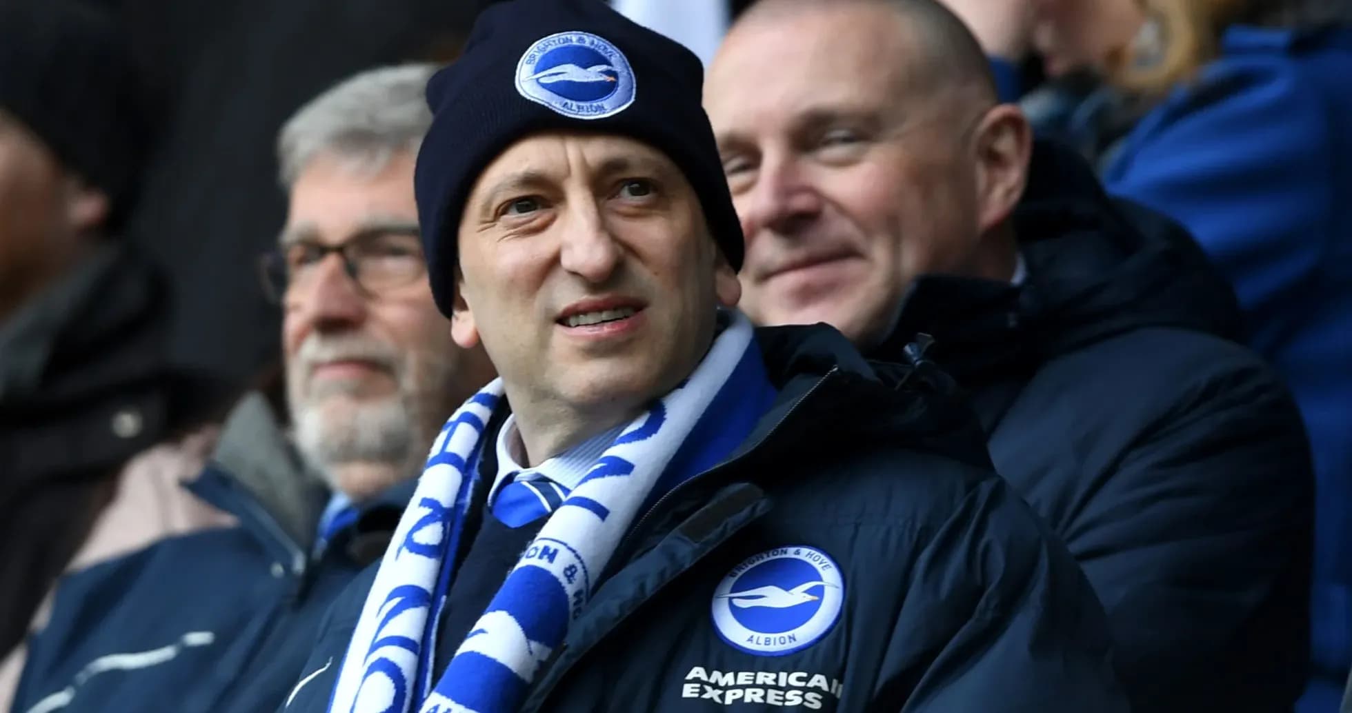 Man wearing Brighton scarf and beanie in stadium