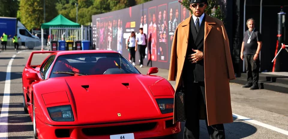 Person in stylish coat beside red Ferrari F40
