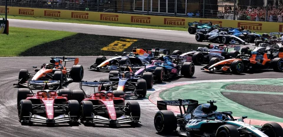 Formula 1 cars racing at a tight corner