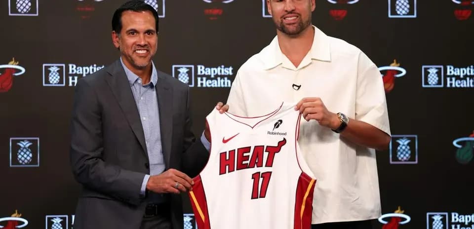 Coach and player presenting Miami Heat jersey