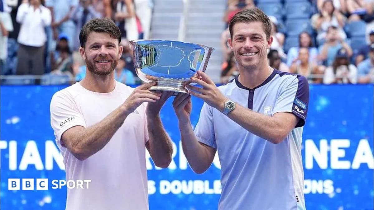 Two tennis players holding a trophy together