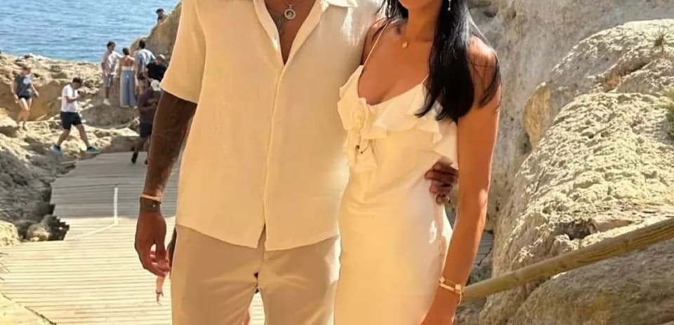 Couple posing on beachside pathway with cliffs