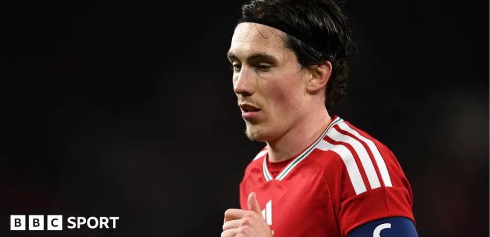 Player in red jersey with captain's armband on pitch