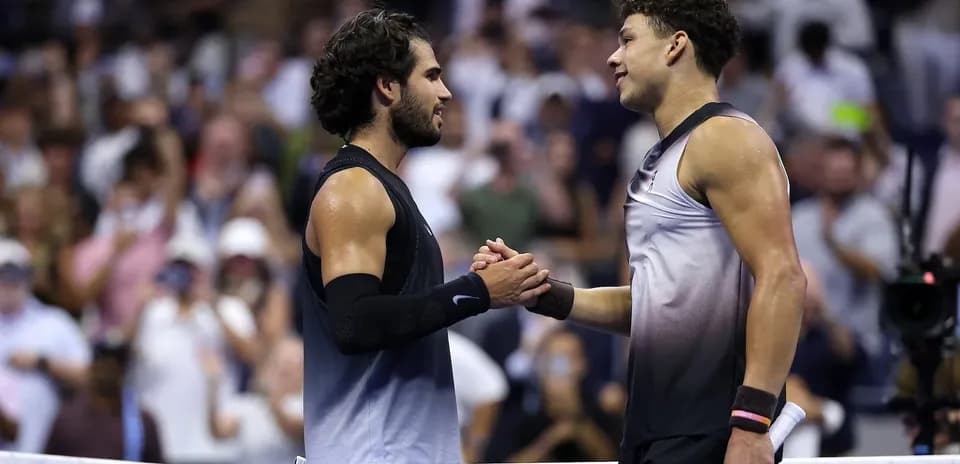Two tennis players shaking hands at the net