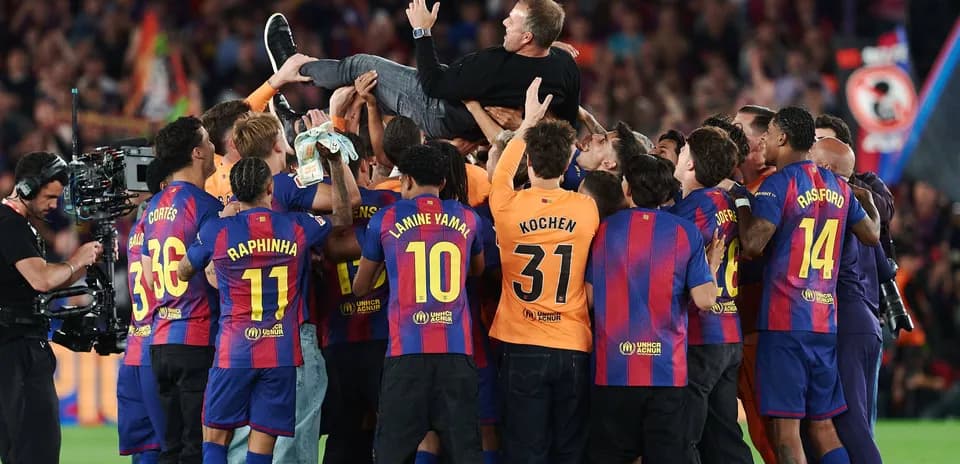 Barcelona team celebrating around their coach