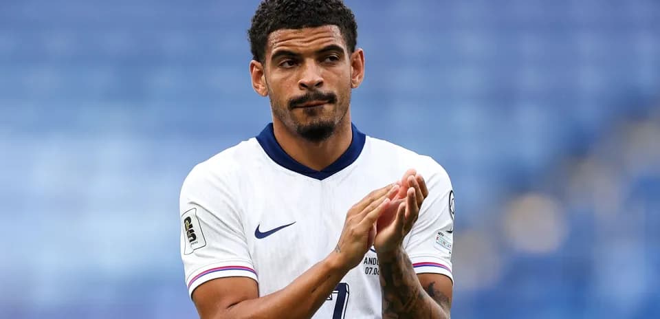 Player applauding in white football kit on pitch