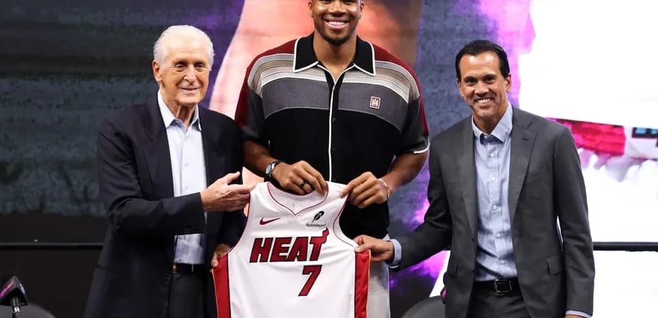 Player holding Miami Heat jersey at press event