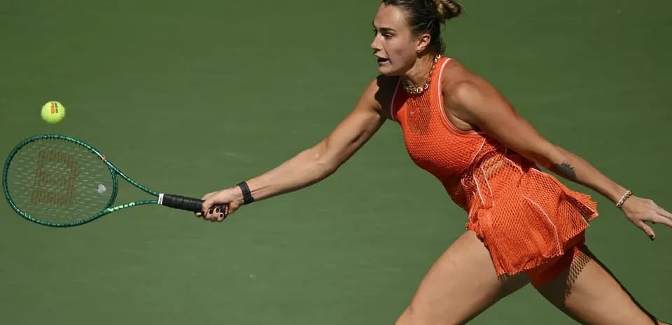 Player reaching for a tennis ball on court