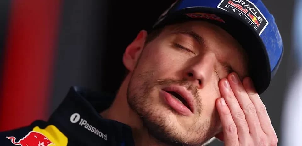 Racing driver with hand on face during press event