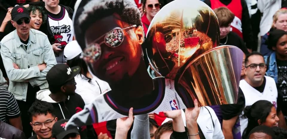 Fans holding large cutout and trophy at celebration