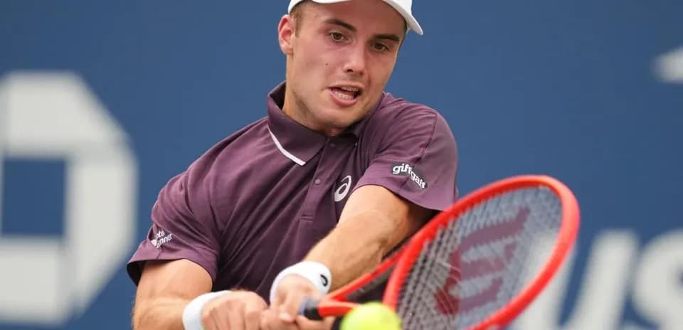 Tennis player hitting a forehand during match