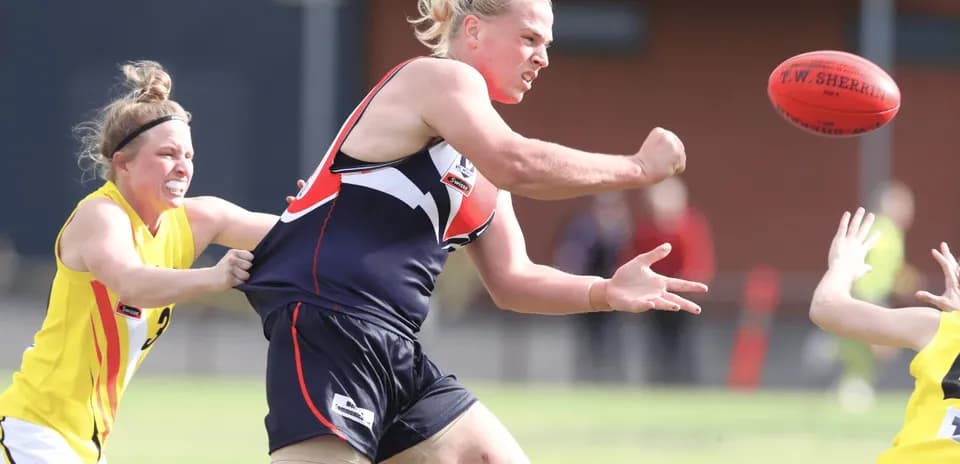 Player attempting to pass ball under pressure from opponent