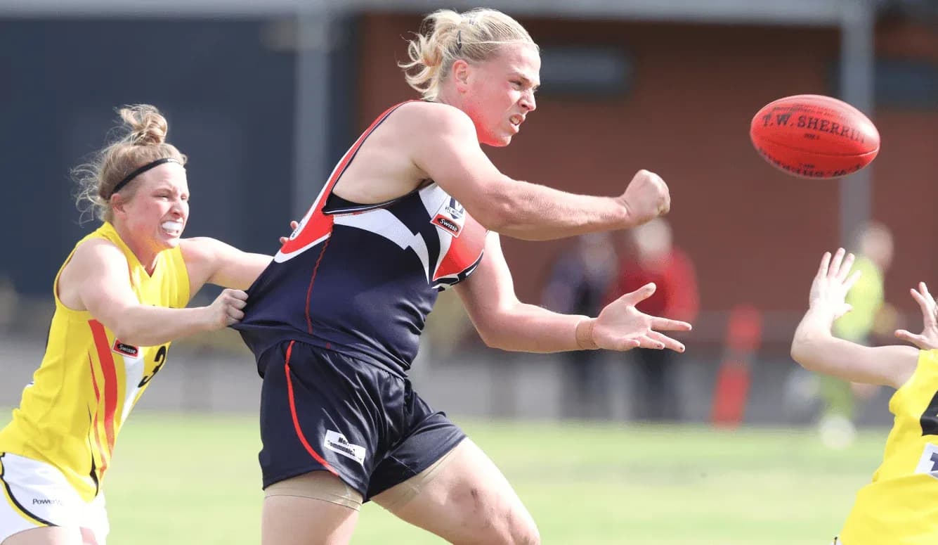 Player attempting to pass ball under pressure from opponent