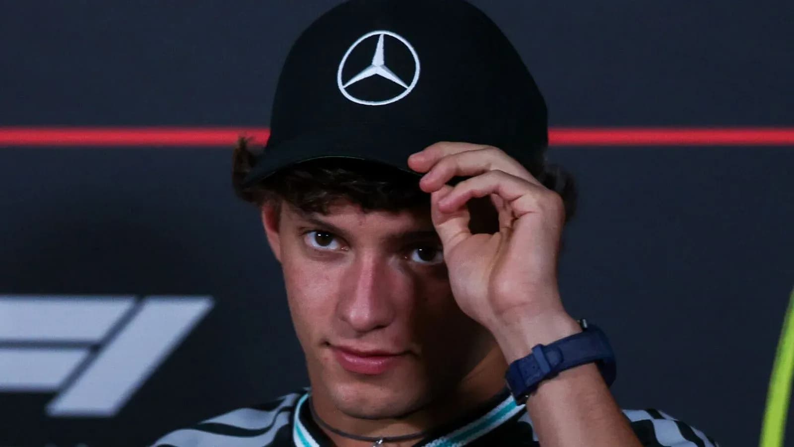 Young man adjusting cap during press conference