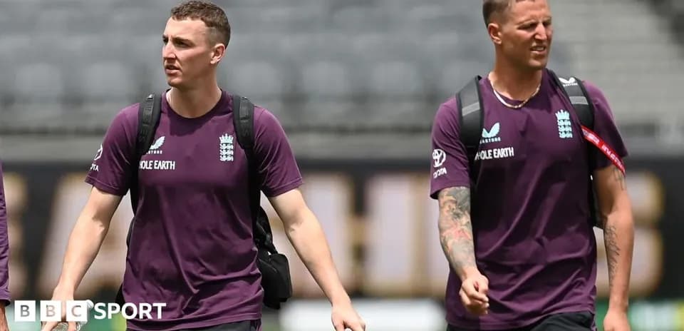 Two England cricket players walking on the pitch