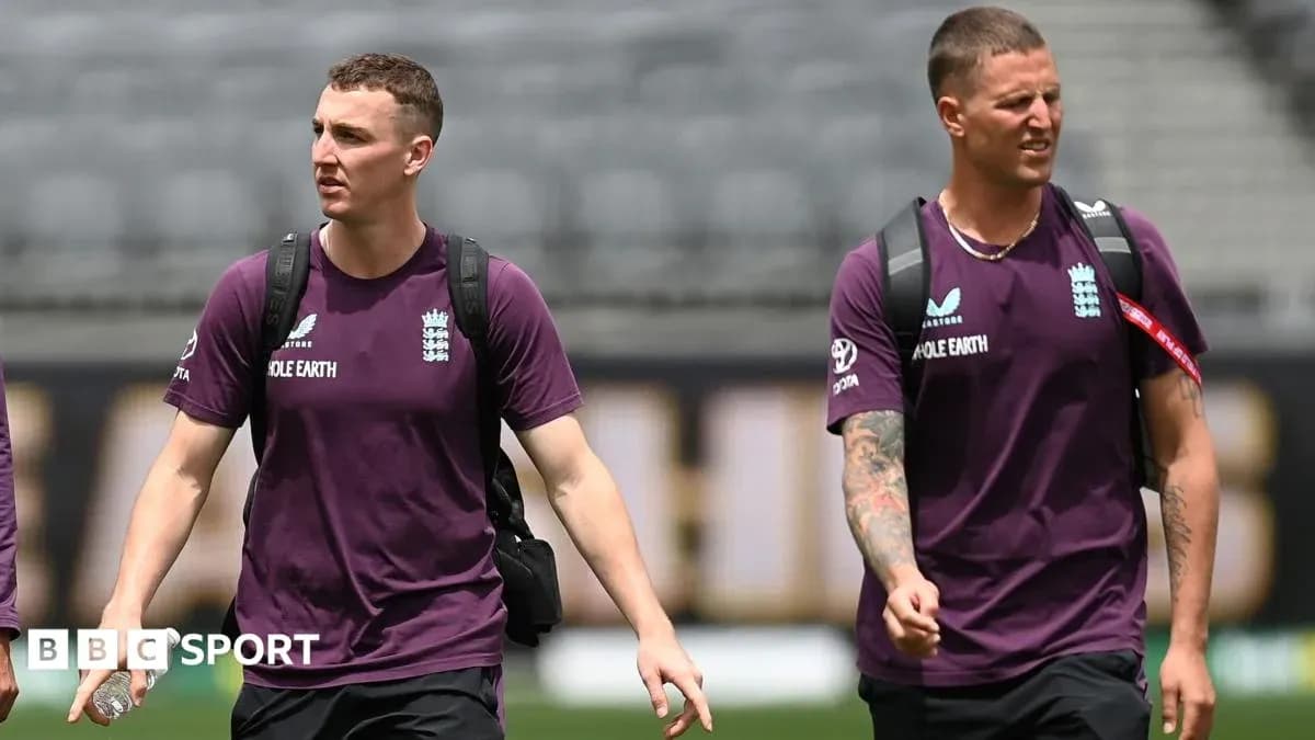 Two England cricket players walking on the pitch