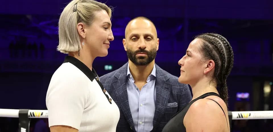 Two fighters facing off with a referee present