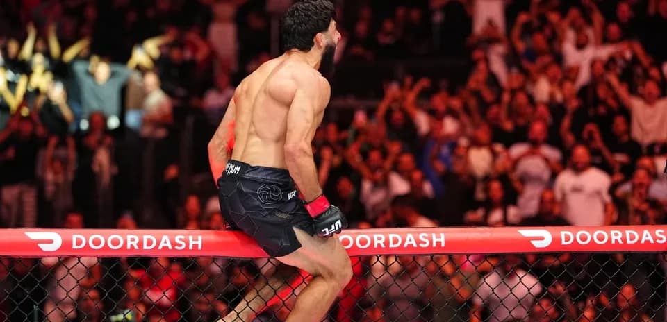 Fighter celebrating on the octagon fence after victory