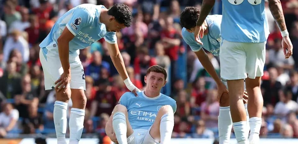 Manchester City players assisting injured teammate on field