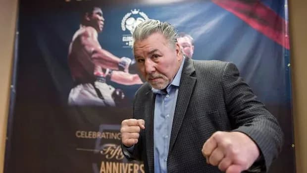 Former boxer posing in front of event backdrop