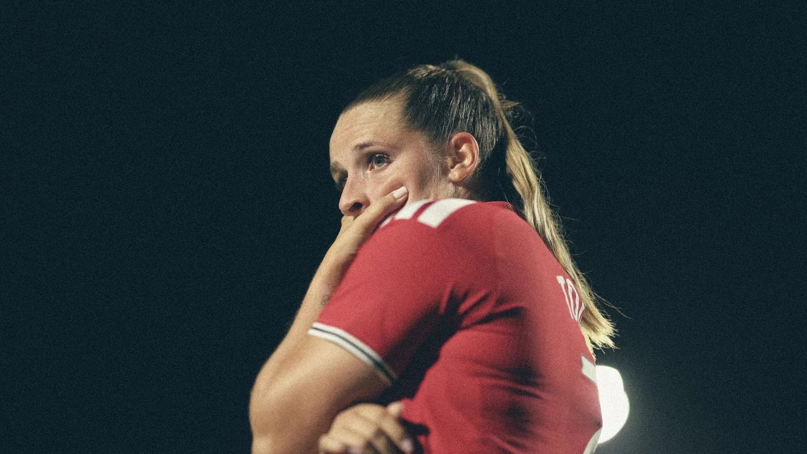 Player in red jersey looking concerned on field