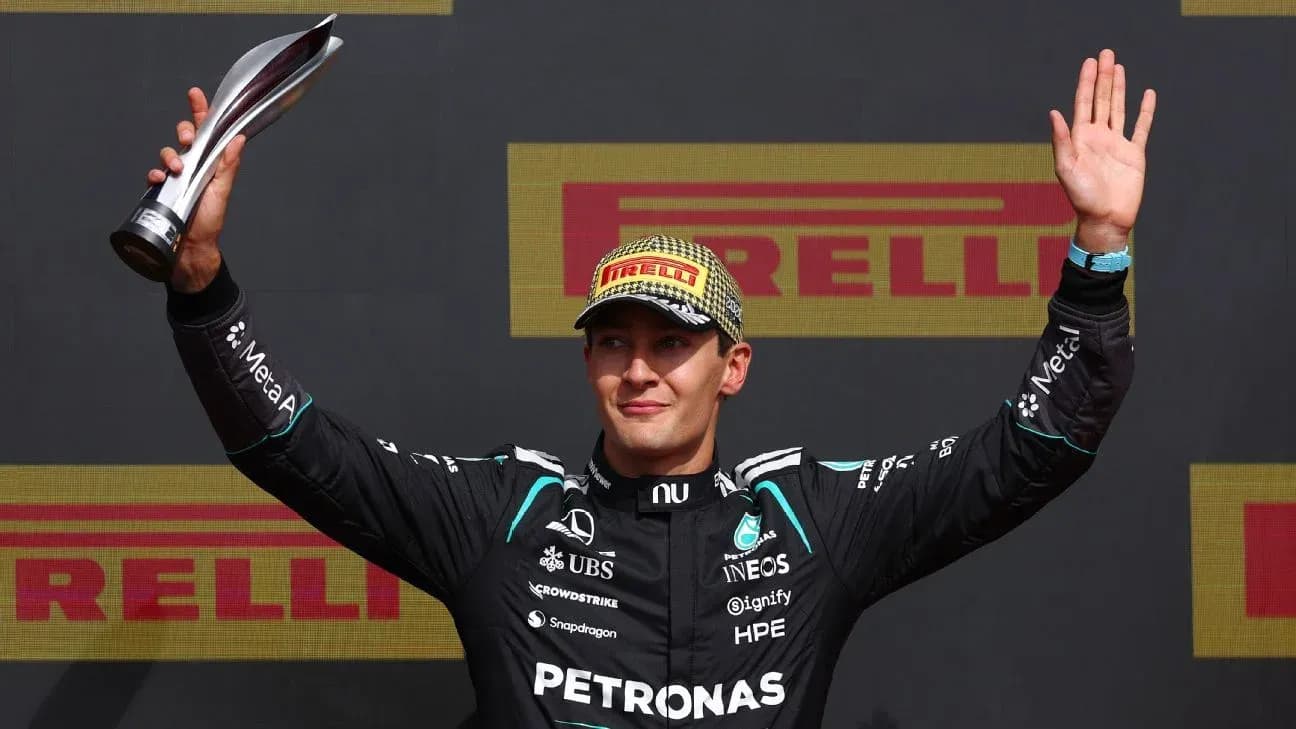 Driver celebrating with trophy on podium after race