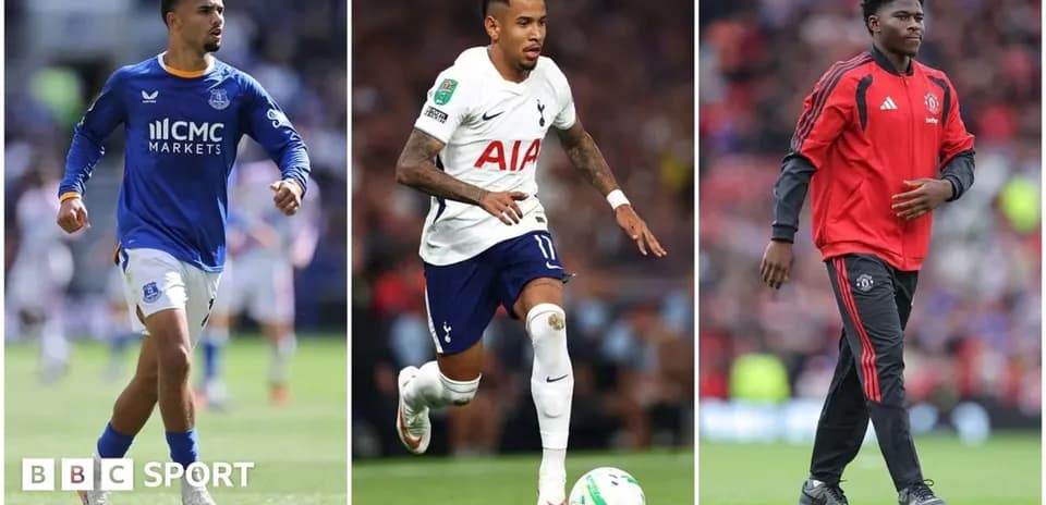 Three football players in team kits during match