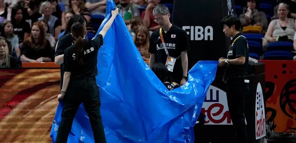 Crew covering court with blue tarp during event