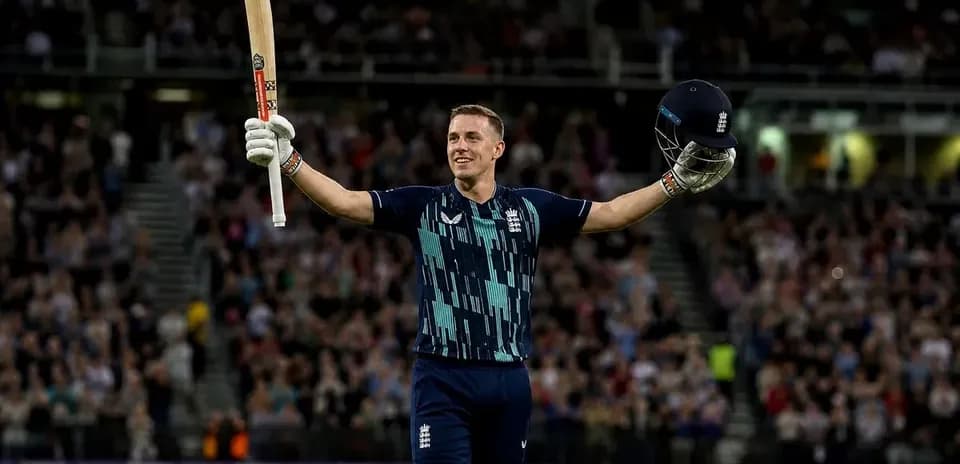 Cricketer celebrating with bat and helmet raised